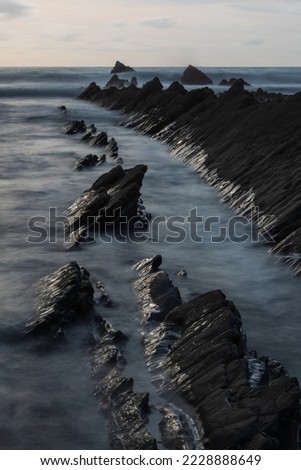 Stunning sunset landscape image of Welcome Mouth Beach in Devon England with beautiful rock formations