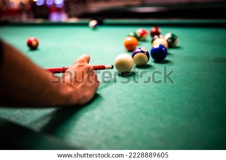 Young man playing snooker, aiming. for a good shot Royalty-Free Stock Photo #2228889605