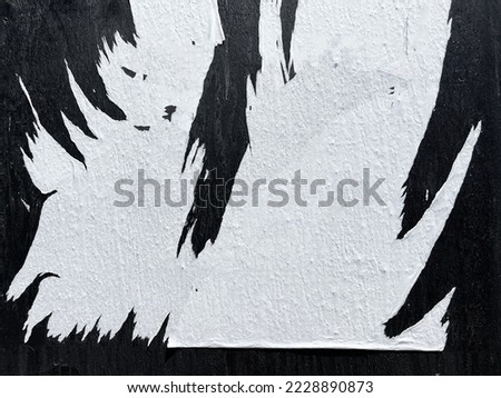 Ripped textured street poster paper on black wooden street fence panel Royalty-Free Stock Photo #2228890873