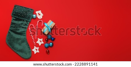 Composition with Christmas sock on red background with space for text