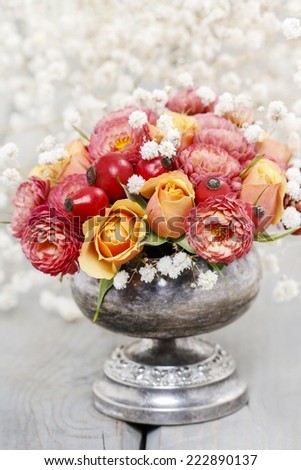 Bouquet of roses and chrysanthemums in vintage silver vase
