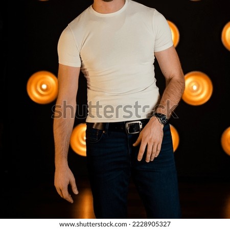Stylish fashionable unrecognizable man in jeans and a white T-shirt.