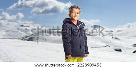 Boy wearing waterproof winter clothes on a snowy mountain