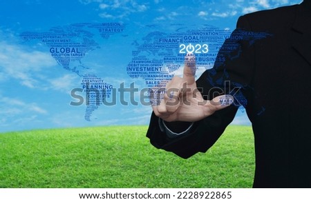 Businessman pressing 2023 start up business icon with global words world map over green grass with sky, Happy new year 2023 global business start up concept, Elements of this image furnished by NASA