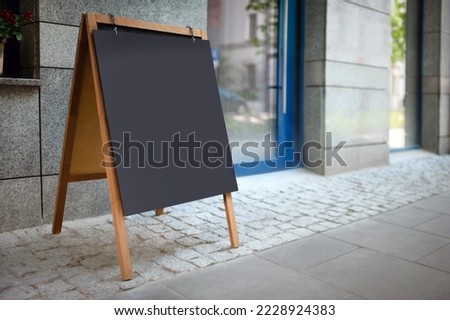 Blank advertising A-board near cafe. Mockup for design