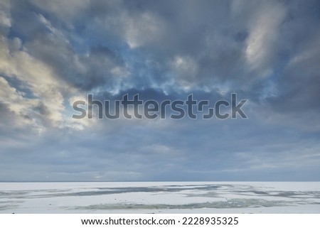 Landscape of the frozen Baltic Sea against the background of the evening sky