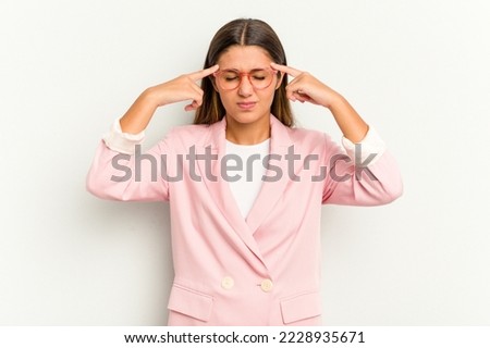 Young Indian woman isolated on white background focused on a task, keeping forefingers pointing head.
