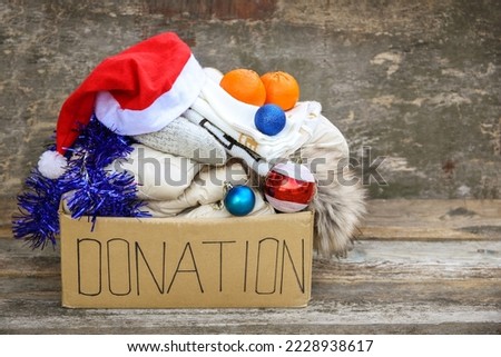 Donation box with winter clothes and with christmas decorations. Gift.