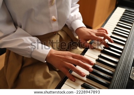 Young woman playing piano, closeup. Music lesson