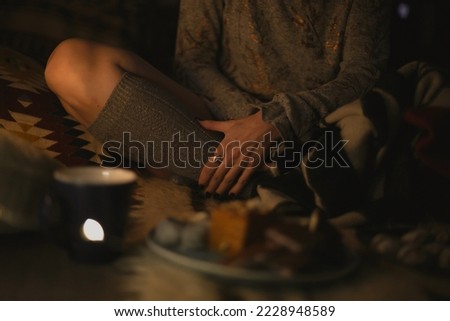 Close up lady sitting lotus pose concept photo. Woolen stocking. Side view photography with cozy interior on background. High quality picture for wallpaper, travel blog, magazine, article