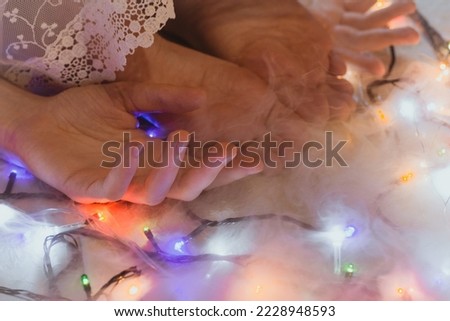 Close up toes and fingers concept photo. Barefoot girl. Side view photography with decorative garlands on background. High quality picture for wallpaper, travel blog, magazine, article