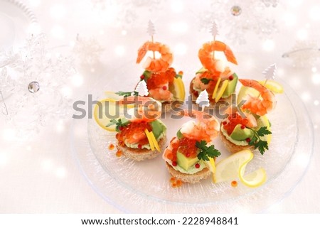 Festive canape with avocado, shrimp, avocado dip and salmon roe  for christmas or new year.
