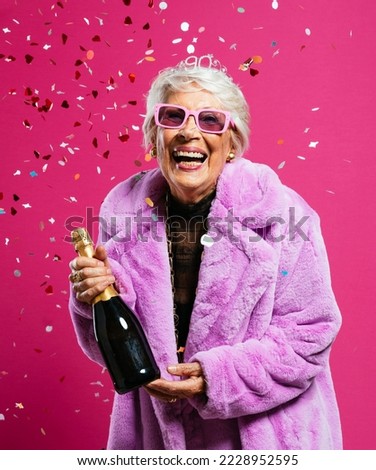 image of a beautiful and elegant old influencer woman. Cool grandmother posing in studio wearing fashionable clothes. Happy senior lady celebrating and making party. 