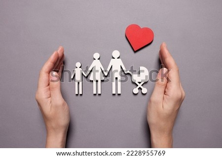 Woman protecting figures of family and heart on lilac background, top view. Insurance concept