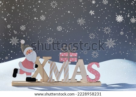 xmas wooden christmas figure with a santa claus on the snow and background with snowflakes