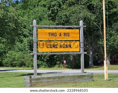 A closeup of a wooden sign that says Thig A Ris and Come Again. The latter is another way or saying come again.