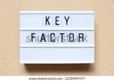 Lightbox with word key factor on wood background