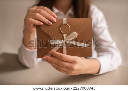 woman in white shirt holding bronze envelope with gift certificate, voucher or discount