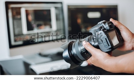 photographer hand camera and computer on desk Royalty-Free Stock Photo #2229006407
