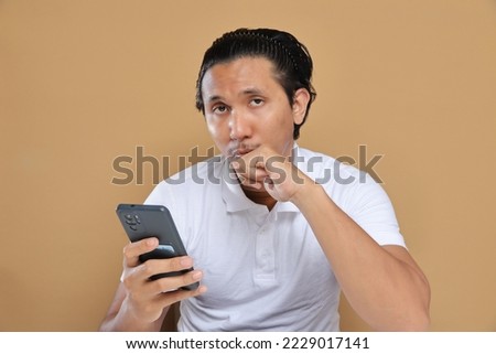 Asian male holding mobile phone. Technology concept.