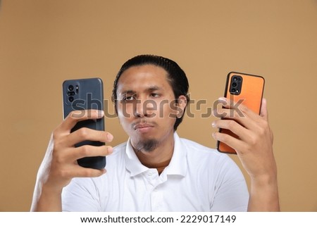 Asian male holding mobile phone. Technology concept.