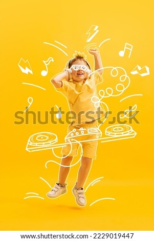 Creative design with drawn elements. Portrait of happy little boy, child posing over yellow background. Future dj, musician. Concept of imagination, childhood, motherhood, creativity, dreams, ad Royalty-Free Stock Photo #2229019447