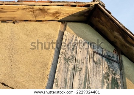 The top of a country house with wooden doors leading to the attic.