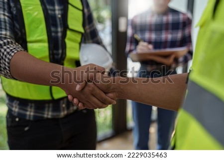 Architect and engineer construction workers shaking hands after finish an agreement in the office construction site, success collaboration concept