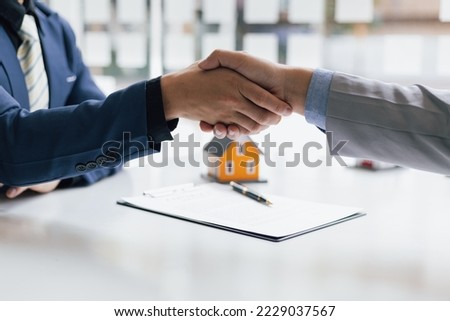 Businessman handshake after reaching a real estate deal. Signing a house rental, mortgage, lease, contract agreement.