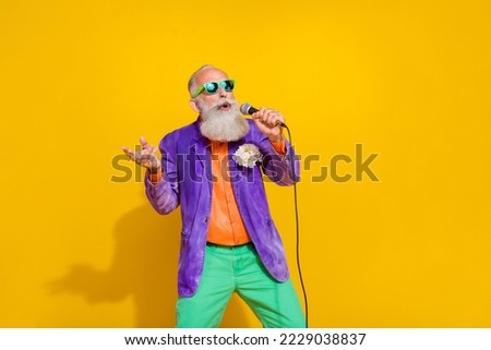 Photo of talented retired man mc performer trendy retro outfit enjoy performance concert empty space isolated on yellow color background
