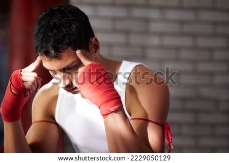 You need to visualise yourself winning. A young fighter mentally preparing before a fight. Royalty-Free Stock Photo #2229050129