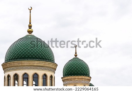 The upper part of the mosque with beautiful green domes and a minaret. Royalty-Free Stock Photo #2229064165