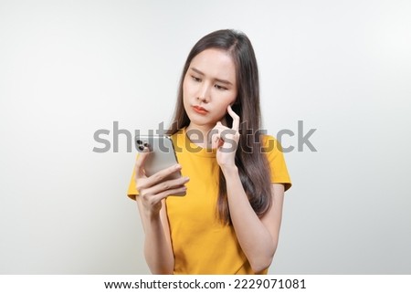 Asian woman reading news in mobile app and wondering fake news. Royalty-Free Stock Photo #2229071081