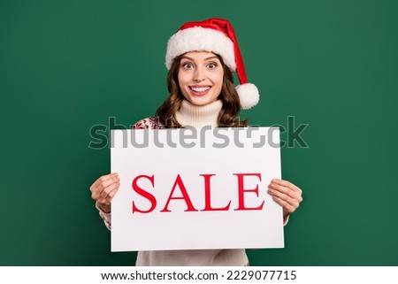 Portrait of positive pretty lady arms hold paper sale advert blank isolated on green color background