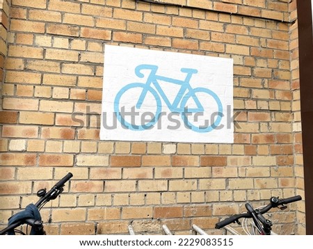 Bicycle parking sign on the facade of a brick building. Selective focus.