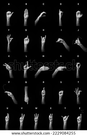 Dramatic black and white image of male hands demonstrating French manual sign language fingerspelling full alphabet with text description