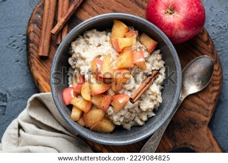 Oatmeal porridge with apple and cinnamon in bowl, top view. Healthy breakfast meal Royalty-Free Stock Photo #2229084825