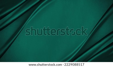 Dark teal green silk satin. Shiny smooth fabric. Soft folds. Luxury background with space for design. web banner. Flat lay, top view table. Birthday, Christmas, Valentine, New year. Royalty-Free Stock Photo #2229088517