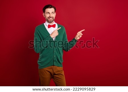 Portrait of cheerful elegant guy toothy smile look indicate fingers empty space isolated on red color background
