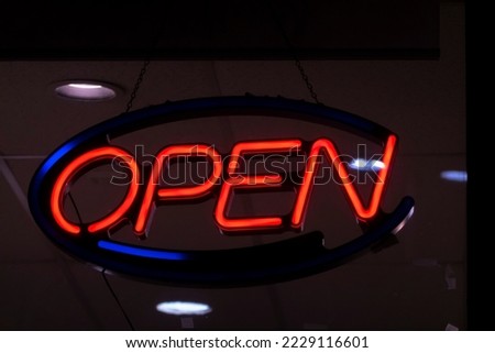 An neon OPEN sign  at night at a store.