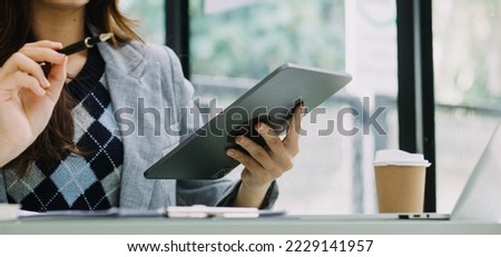 Woman hand using smart phone and laptop in outdoor nature park and sunset sky with bokeh light abstract background. Technology business and freelance working concept. Vintage tone filter color style.