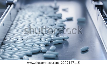 Closse-up shot of White Pills on Conveyor at Modern Pharmaceutical Factory. Tablet and Capsule Manufacturing Process. Close-up Shot of Medical Drug Production Line.