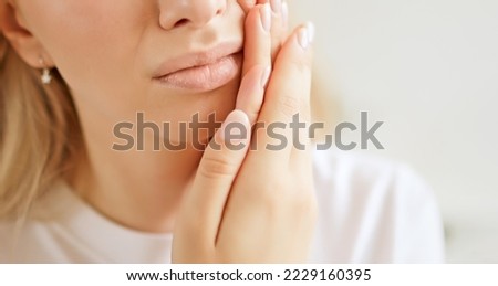 Close up woman with a toothache, touching her face. The concept of dental disease. Tooth pain due to caries Royalty-Free Stock Photo #2229160395