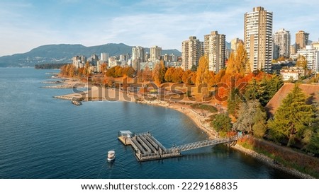 Scenic aerial image of Vancouver's West End and beach with buildings and North Vancouver mountains in the background