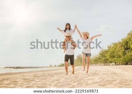 Family day. Happy family people having fun in summer vacation run on beach, daughter riding on father back and mother running at sand beach, family trip playing together outdoor, traveling in holiday Royalty-Free Stock Photo #2229169871
