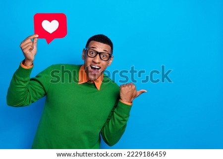 Portrait photo of young excited man wear glasses surprised finger direct mockup subscribe new youtube channel isolated on blue color background