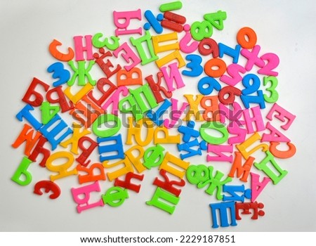 multi-colored plastic letters of Russian alphabets and numbers on a white magnetic board. teaching literacy, Russian language and mathematics at home in a playful way