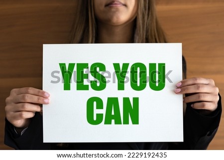 Yes you can. Woman holds a white page with green text. Inspiration, motivation, business, encouragement and the way forward.