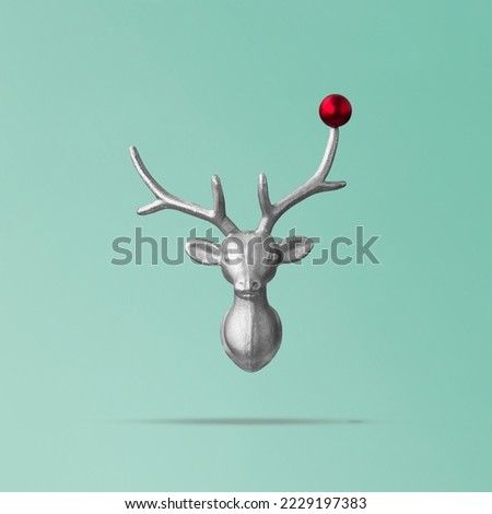 Christmas reindeer concept on teal background made of reindeer head and red bauble. Minimal winter vacation idea, new year concept