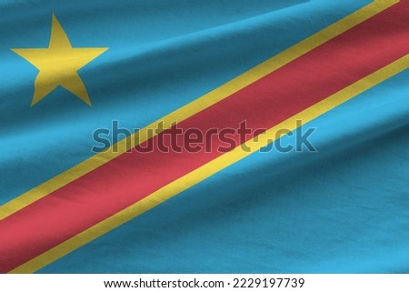Democratic Republic of the Congo flag with big folds waving close up under the studio light indoors. The official symbols and colors in fabric banner